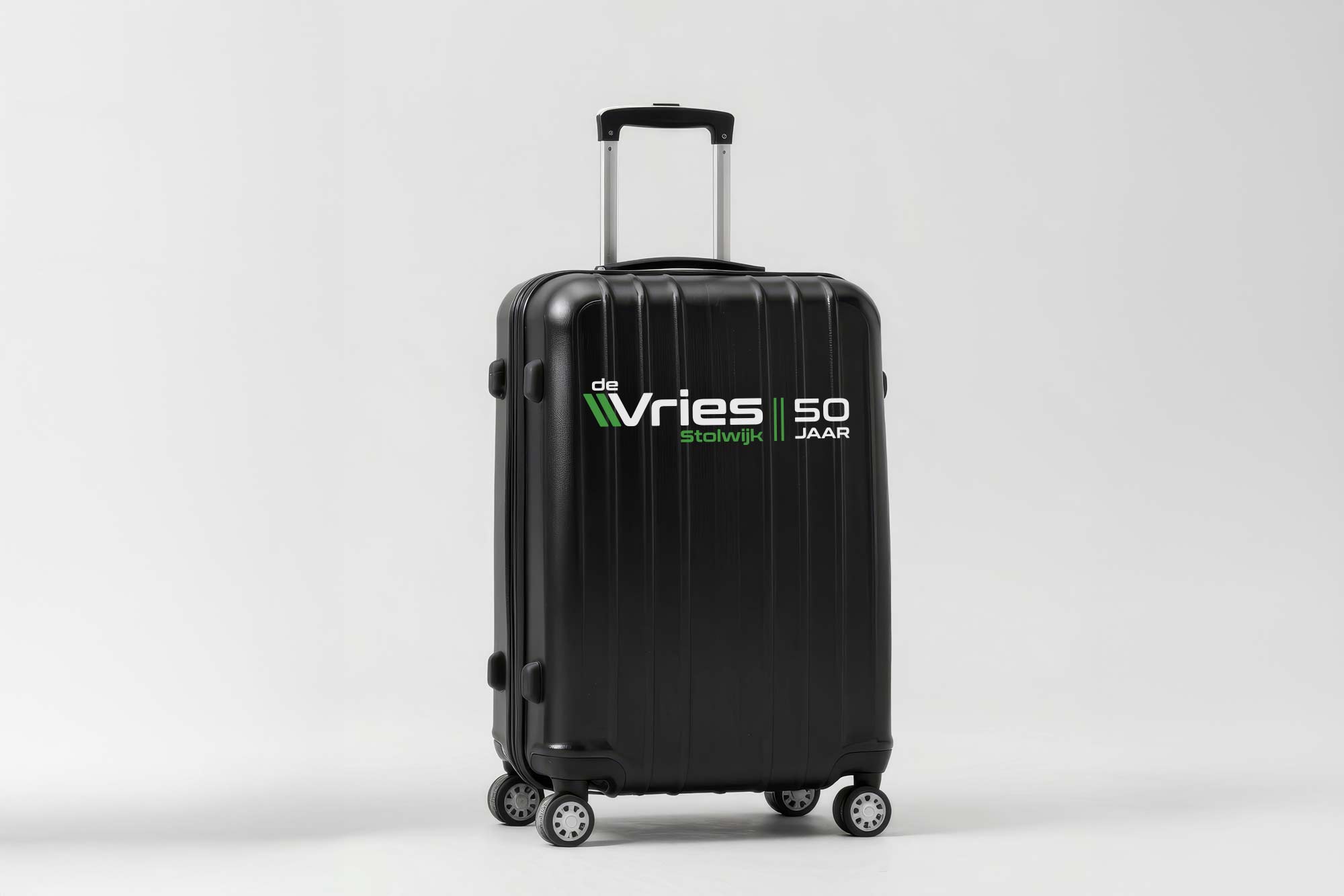 BURO210 Fullservice Marketingbureau Zwarte reiskoffer van De Vries Stolwijk, speciaal voor 50-jarig jubileum. Ideaal voor zakenreizen of vakantie. Duurzaam en stijlvol ontwerp.